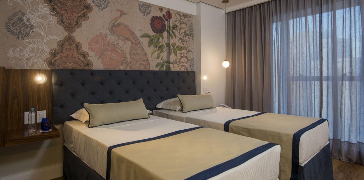 Hotel Luzeiros Recife Luaran gambar The photo shows a modern bedroom featuring two single beds that are neatly made with light-colored blankets and decorative pillows. The headboard of the beds is upholstered in a dark material, giving it a stylish appearance. Behind the beds, there is